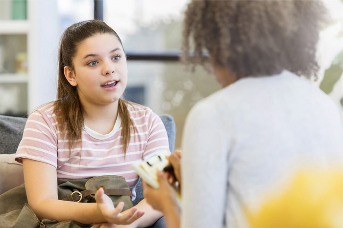 A young girl talking expressively to a counsellor