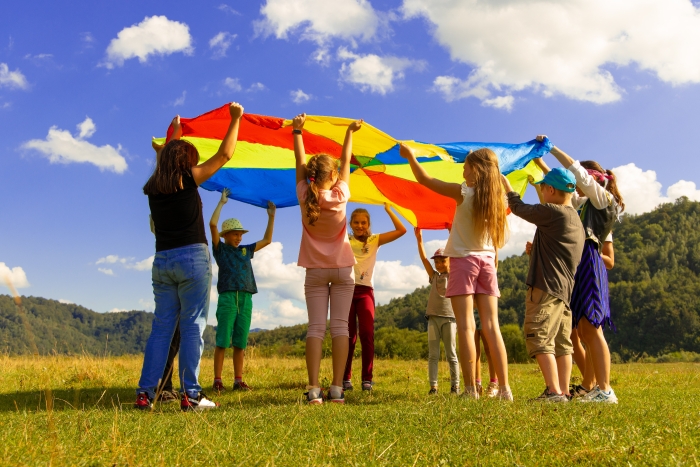 Children Playing Outdoors With Colourful Parachute.jpg