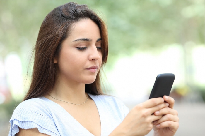 A young person looking at and using her smartphone